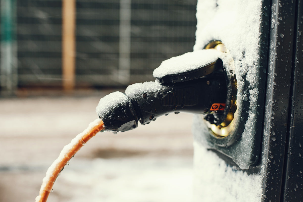Coiled cold‑weather SJEOW extension cord, RV surge protector, and generator cord laid out on a workbench for winter inspection